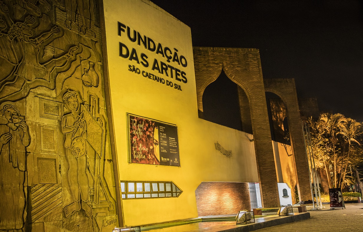 Fachada com inscrições e desenhos nas paredes, na parede central amarela está escrito o nome da Instituição: Fundação das Artes São Caetano do Sul.  